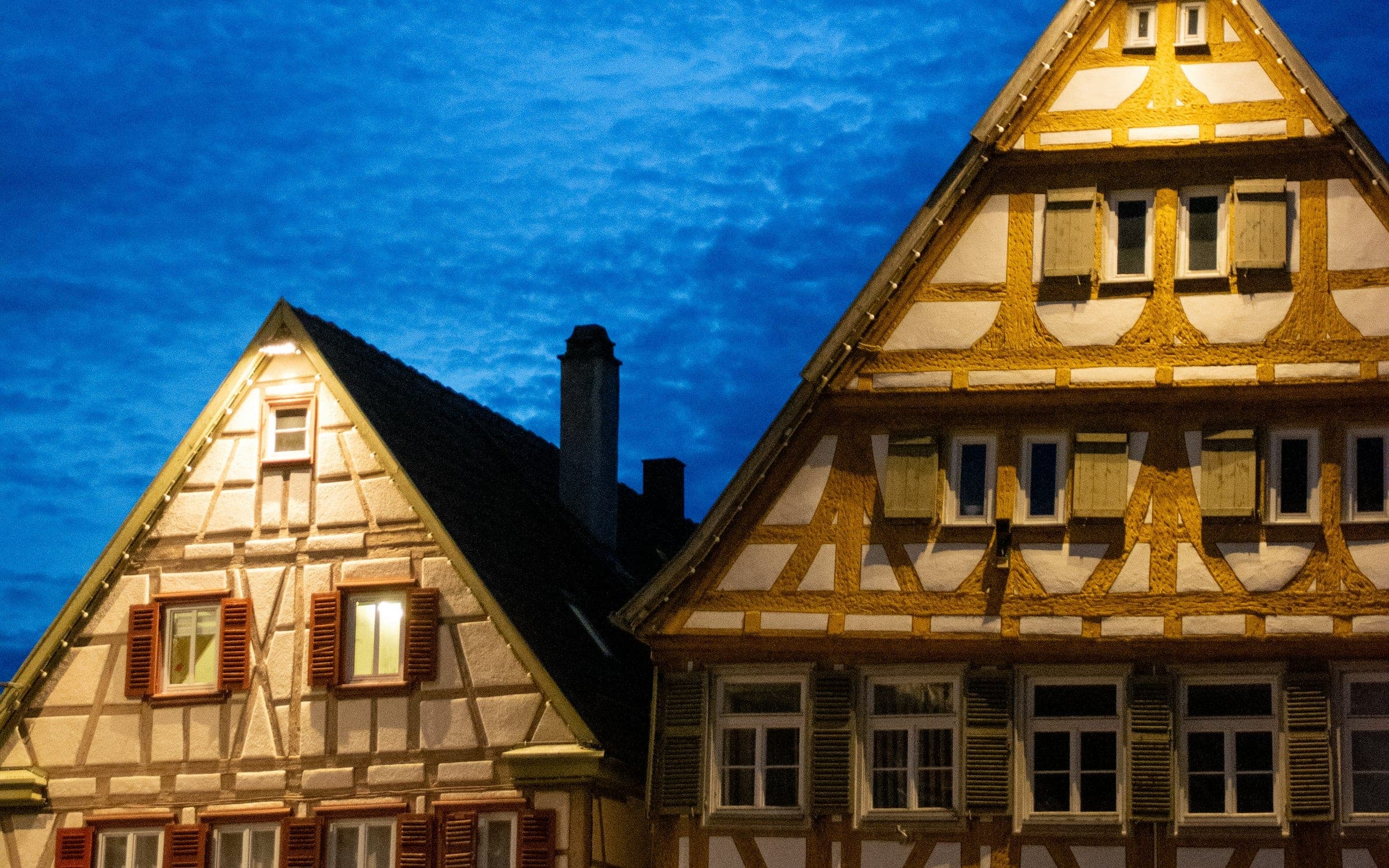 Modernes Wohnhaus in der Abenddämmerung mit warm erleuchteten Fenstern