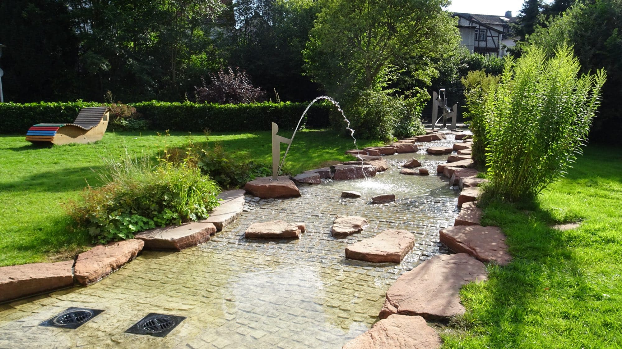 Kneipp-Becken mit Wasserspiel im Kurpark von Bad Endbach an einem sonnigen Tag