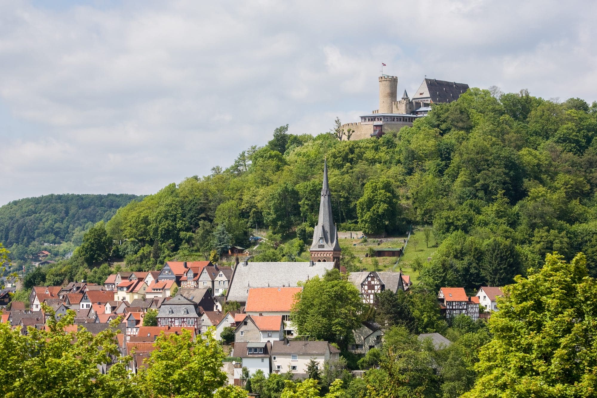 Altstadt von Biedenkopf mit der Stadtkirche, darüber das Landgrafenschloss auf dem bewaldeten Schlossberg