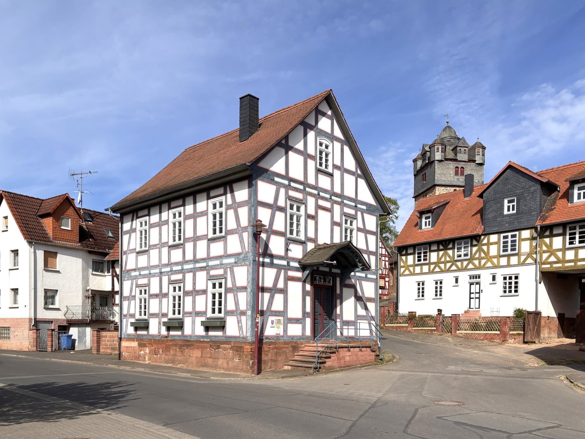 Ehemaliges Fachwerk-Rathaus in der Rathausstraße von Fronhausen, dahinter der Turm der evangelischen Kirche